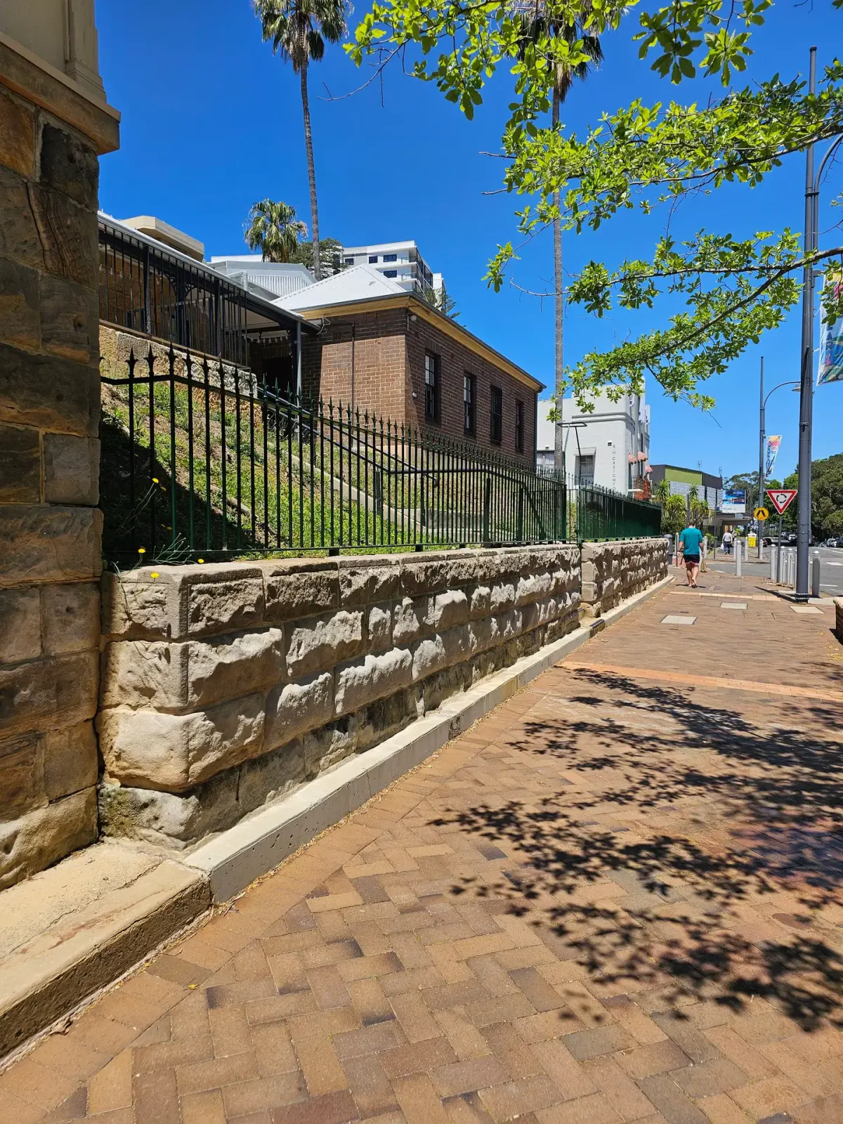 Restored heritage sandstone retaining wall beside a Sydney streetscape