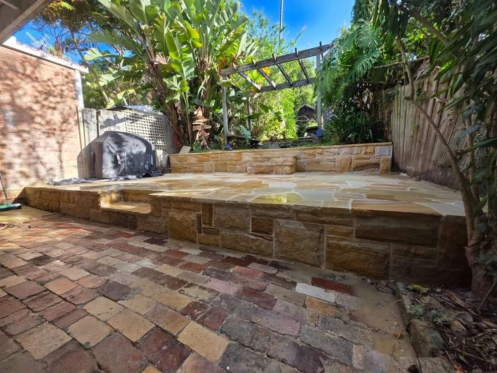 Sandstone terrace and retaining wall in a landscaped Fairlight garden